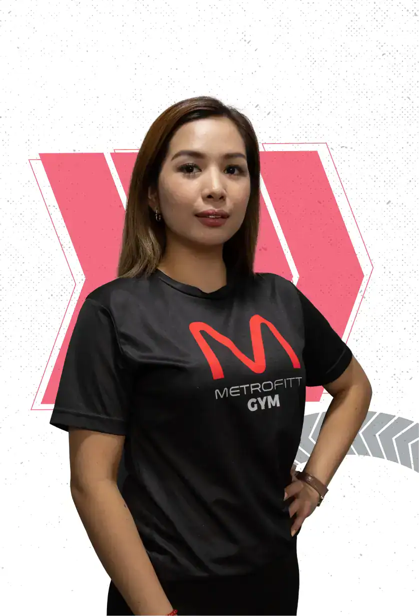 A woman stands confidently wearing a black "METROFITT GYM" t-shirt with a red "M" logo, against a white background with geometric red and gray designs.